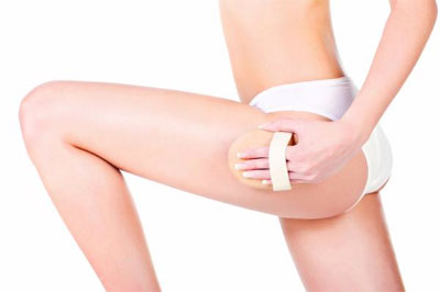 Woman Dry Brushing Leg with Hand-Held Dry Brush